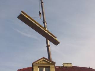 Zvedání nosníku jeřábem nad střechou domu